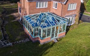 Chartwell green uPVC T-Shaped conservatory with a glass roof